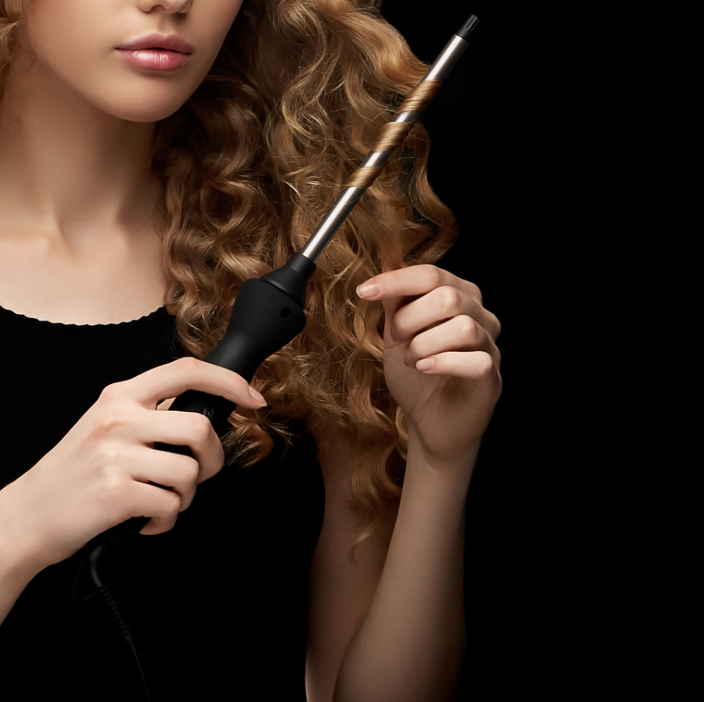 Девушка завивает волосы стайлером Polaris PHS 1509TAi stick Argan Therapy PRO