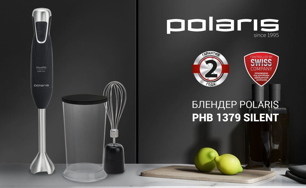 Погружной блендер Polaris PHB 1379 Silent стоит на столе вместе с аксессуарами, рядом с доской с лимонами
